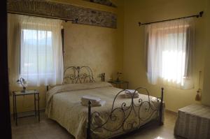 a bedroom with a bed and two windows at Valle degli Agrumi in San Pier Niceto