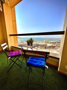 ドバイにあるYork Backpackers - Jumeirah Beachの大きな窓の前にテーブルと椅子2脚