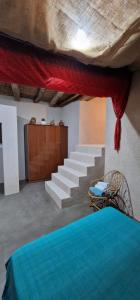 a bedroom with a bed and a staircase with red curtains at EL CAU DE CAL VIOLA in Torroja +38 photos
