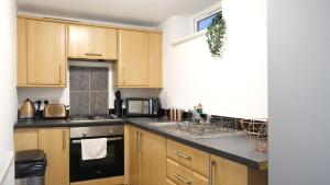 a kitchen with wooden cabinets and a stove top oven at Free Parking & Garden & Central Contractor in Bedford