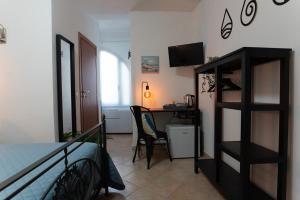 una camera da letto con un letto e una scrivania con un computer di Residenza della Laguna a Orbetello