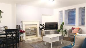 a living room with a fireplace and a television at Free Parking & Garden & Central Contractor in Bedford