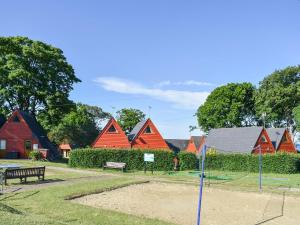 a group of red wooden houses with a park at Poppy Lodge in Kingsdown