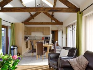 a kitchen and living room with a table and chairs at Little Hendre Lodge - Uk10262 in Penrhôs