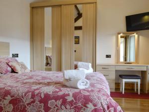 1 dormitorio con 1 cama con toallas en Little Hendre Lodge - Uk10262, en Penrhôs