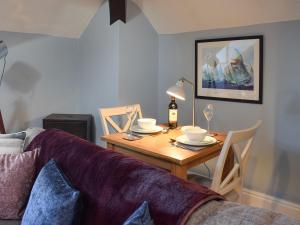 uma sala de estar com uma mesa e um sofá em Skylight em Saltburn-by-the-Sea