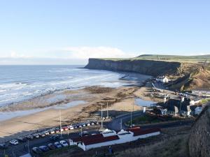 a group of cars parked on a beach next to the ocean at Skylight in Saltburn-by-the-Sea