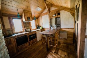 eine Küche mit Holzböden und einem Holztisch in der Unterkunft Le Moulin d' Erée, gîte Insolite de charme in Soudan