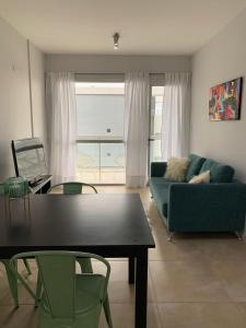 uma sala de estar com um sofá azul e uma mesa em Los Cardos Suites em Neuquén