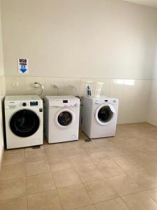 três máquinas de lavar roupa e uma máquina de lavar e secar roupa num quarto em Los Cardos Suites em Neuquén