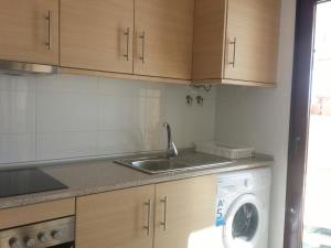 a kitchen with a sink and a washing machine at Apartment Mojon Hills in Isla Plana