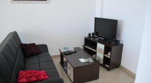 sala de estar con sofá y TV de pantalla plana en Apartment Mojon Hills, en Isla Plana