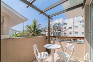 a balcony with a table and chairs and a view of a building at Com 01 dormitório é para entrar e ser feliz in Bombinhas