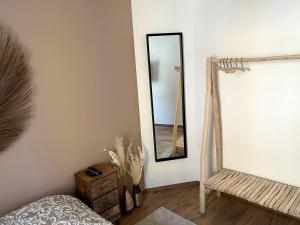 una camera da letto con specchio e tavolo in legno di Belle chambre cosy, proche centre-ville et gare a Colmar