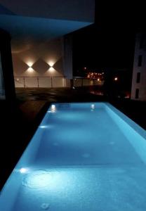 uma piscina iluminada à noite num edifício em Luna Boutique Hotel em Mindelo