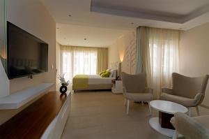 a hotel room with a bed and a flat screen tv at Luna Boutique Hotel in Mindelo