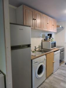 eine Küche mit einem Kühlschrank und einer Waschmaschine in der Unterkunft La Bouee, entre Manche et Seine 