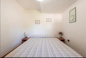 een slaapkamer met een bed met een geruite sprei bij Geremeas Country Club in Torre delle Stelle