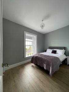 Un dormitorio con una cama grande y una ventana en Tonn Ruray Sea View Luxury 2 Bed Apartment en Dundrum