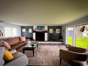 ein Wohnzimmer mit einem Sofa und einem Kamin in der Unterkunft 60 Bentons Lane Prince Edward County Ontario in Waupoos