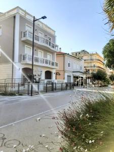 a city street with a building and a fence at Residenza Mediterranea Apartments in Rimini