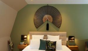 a bedroom with a large fan above a bed at Les Berges in Bourbourg