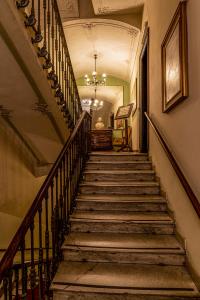 una escalera en un edificio antiguo con una lámpara de araña en Hotel Antica Dogana en Turín