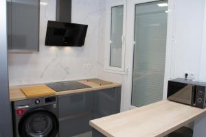 a kitchen with a washing machine and a microwave at Nuevo Apartamento Sevilla centro, Trastamara 25 in Seville