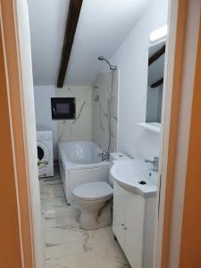 a white bathroom with a toilet and a sink at Jolie Art in Brăila