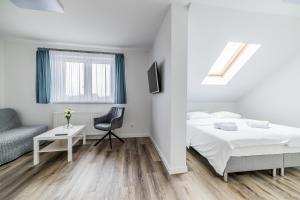 a white bedroom with a bed and a desk at EXPO HOSTEL in Kielce
