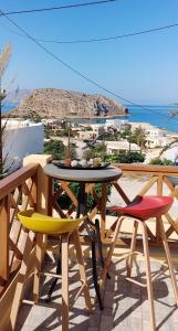 una mesa y sillas en un balcón con vistas al océano en Stavlos Country House en Arkasa