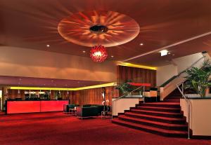 - un hall avec des escaliers et un tapis rouge dans l'établissement Best Western Plaza Hotel Wels, à Wels