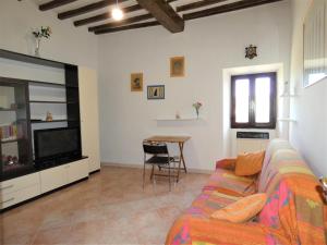 een woonkamer met een bank en een televisie bij Scappo in Umbria, La casa di Soel in Amelia