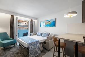 パルマ・デ・マヨルカにあるFeelathome Tortuga de Marのベッドとテーブル付きの小さな部屋