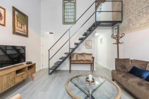 salon z kanapą i szklanym stołem w obiekcie The Bullring Suites w Sewilli +8 zdjęć