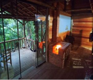 - une cheminée sur la terrasse couverte d'une maison en bois dans l'établissement Cabanas Pousada Esmeraldas, à Annitapolis