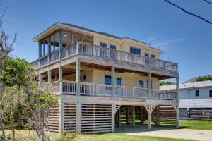 a large yellow house with a large deck at Porch Song in Kitty Hawk