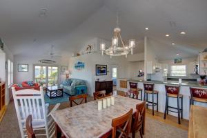 a kitchen and living room with a table and chairs at Porch Song in Kitty Hawk