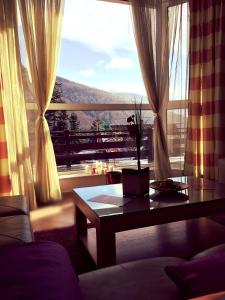 a living room with a table and a large window at Roberto Hotel in Sinaia