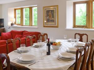 mesa de comedor con copas de vino y sofá rojo en Cumberland House en Orton
