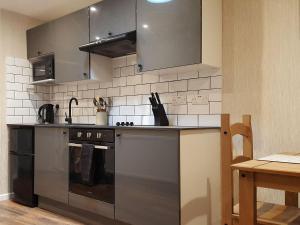 a kitchen with stainless steel appliances and a table at Cobblers Cottage in Dalton in Furness