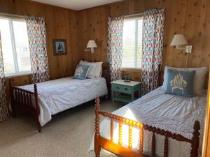 - 2 lits dans une chambre dotée de murs en bois et de fenêtres dans l'établissement Summersalt, à Southern Shores 36 autres photos