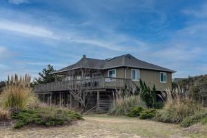 une grande maison avec une terrasse sur une colline dans l'établissement Summersalt, à Southern Shores