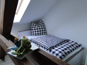 Una cama pequeña en una habitación con juguetes en una mesa. en Fewo Jüterbog City, en Jüterbog