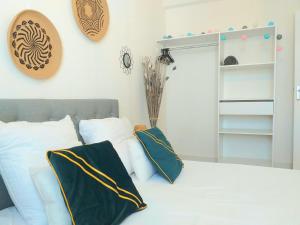 - une chambre avec un lit doté d'oreillers verts et blancs dans l'établissement Le Tigre - Appartement centre-ville au calme, parking privé, à Bourges