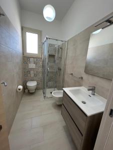 a bathroom with a sink and a shower and a toilet at QUASI NELL'ACQUA in Torre Pali 