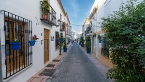 an alley in an old town with potted plants at Veranera Hostel in Estepona