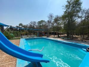 a swimming pool with a blue water slide at Hotel Campestre Iparoma in Estancia Campo Aroma