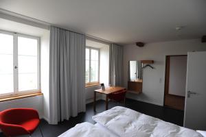 a hotel room with a bed and a desk and window at Kloster Kappel in Kappel am Albis