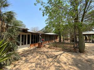a house with a tree in front of it at Hotel Campestre Iparoma in Estancia Campo Aroma